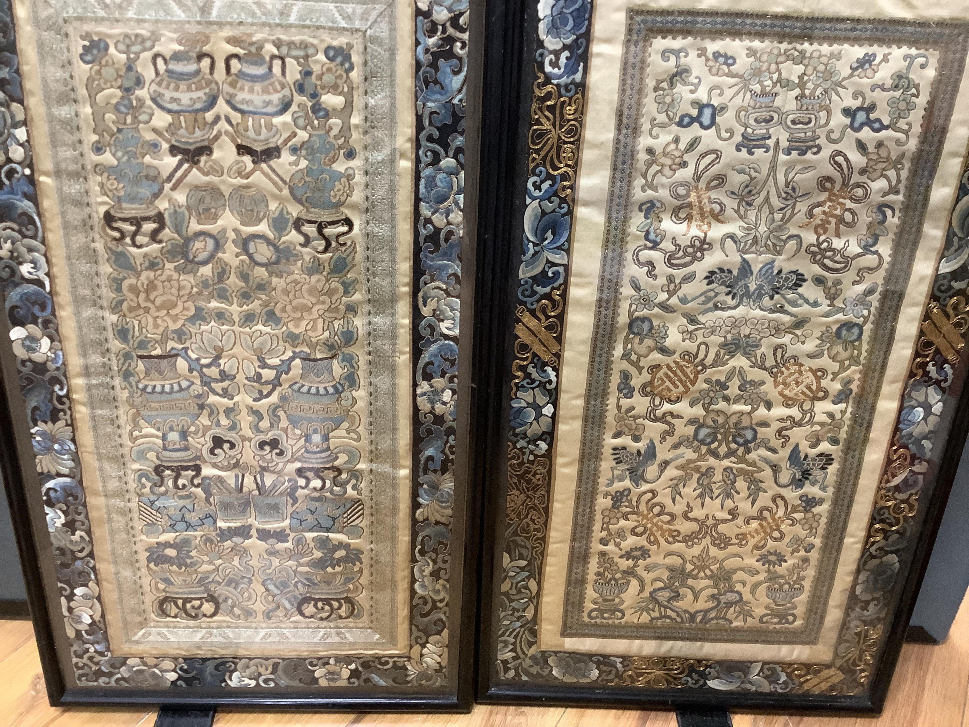 Two pairs of 19th century Chinese, Peking knot, silk embroidered sleeve bands. Worked on cream silk. Both embroidered mostly in blues and gilt thread, in flower, bird and auspicious motifs, both bordered with black silk